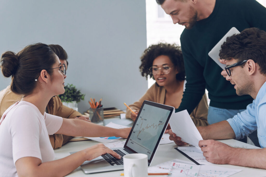 Group of employees discussing how employee relations can provide support during challenging economic times.